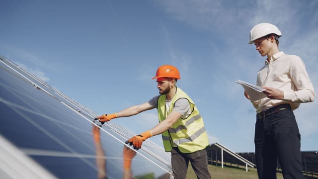 Technicy sprawdzają instalację paneli słonecznych.