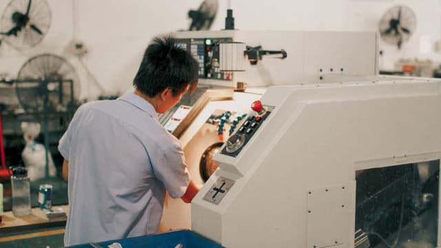 Operator obsługuje maszynę produkcyjną w zakładzie.